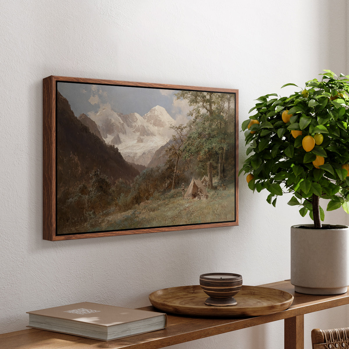 Landscape in the Caucasus, c. 1921 by Edward Theodore Compton, presented in a walnut floater framed canvas featuring a mountainous landscape with rugged terrain and distant peaks, displayed above a hallway console table.