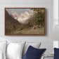 Landscape in the Caucasus, c. 1921 by Edward Theodore Compton displayed above a sofa in a living room in a walnut floater frame, featuring an expansive view of Caucasus mountains under open sky.