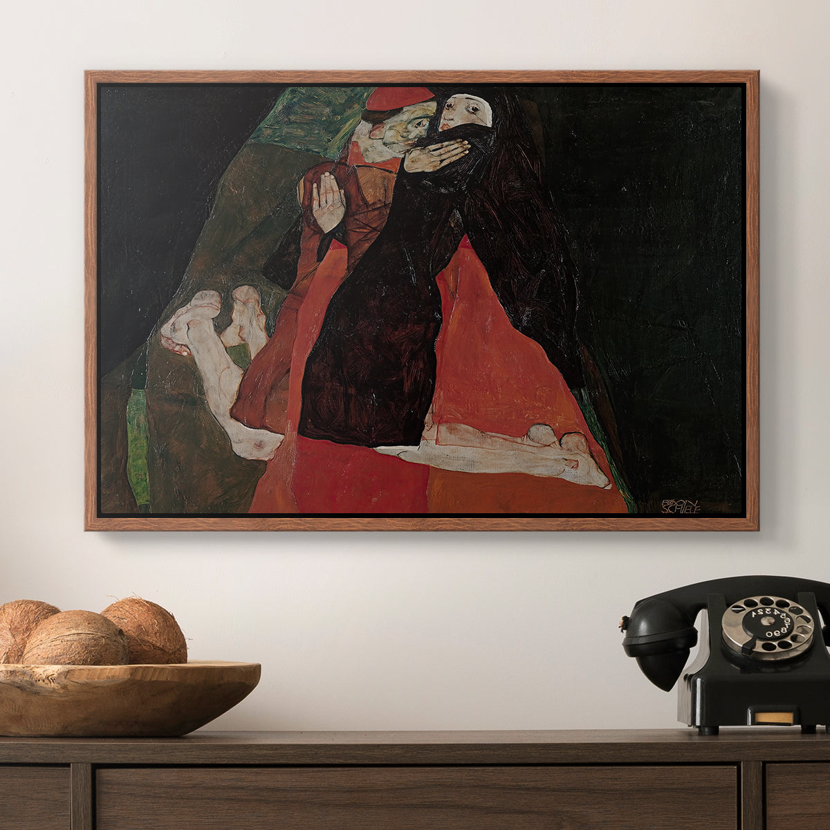 Cardinal and Nun (Caress), 1912 by Egon Schiele in a walnut floater framed canvas displayed above a console table in a hallway, featuring an intimate scene with religious figures in modernist style.