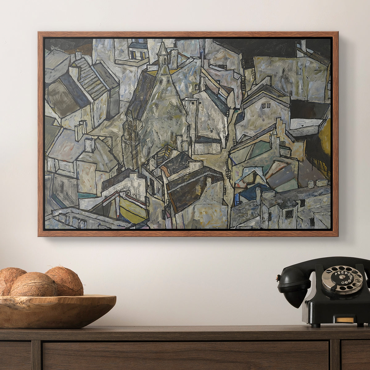Mödling II, 1918 by Egon Schiele in a walnut floater framed canvas displayed above a console table in a hallway, featuring a stylized urban composition with geometric structures and muted tones.