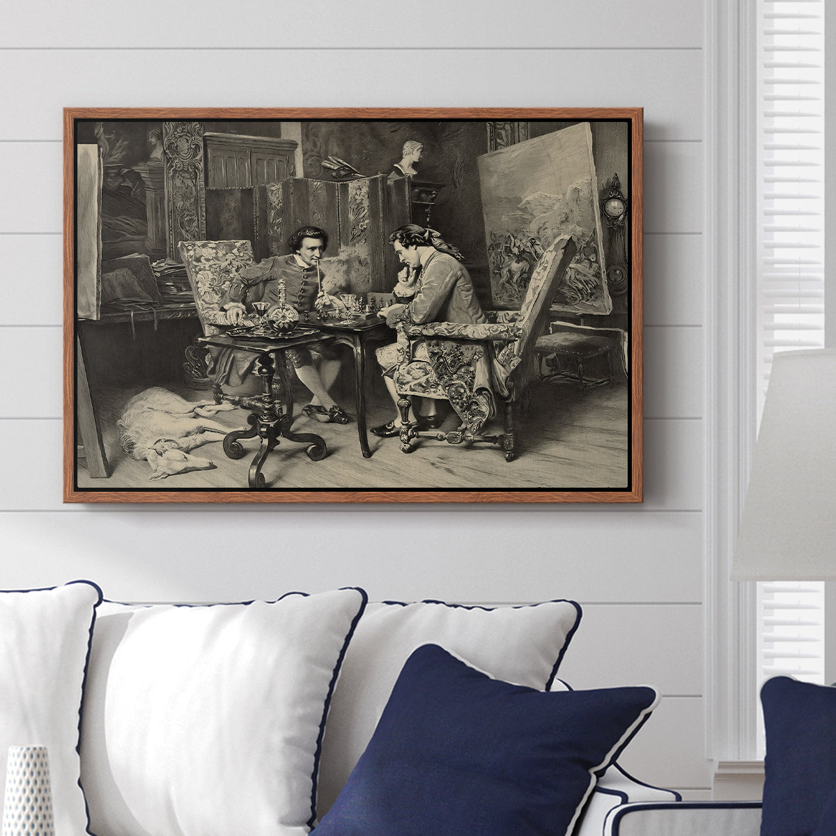 The Chess Players, 1858 by Ernest Meissonier displayed above a sofa in a living room in a walnut floater frame, featuring a realistic scene of figures concentrating on chess game indoors.