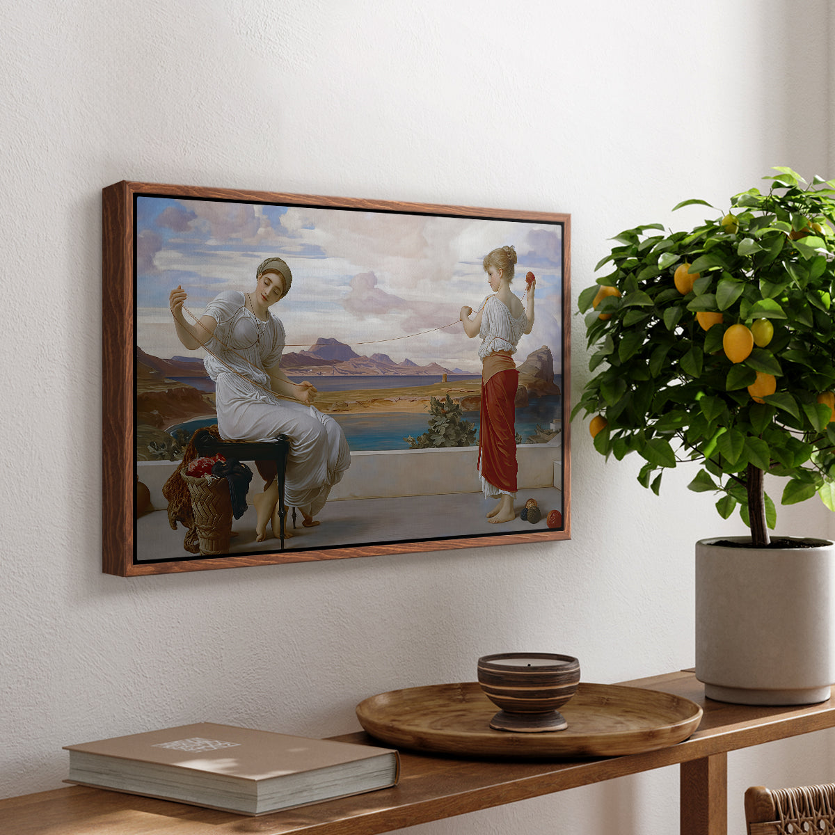 Winding the Skein, c. 1878 by Frederic Leighton, presented in a walnut floater framed canvas featuring a woman holding thread while another figure helps wind yarn in classical setting, displayed above a hallway console table.