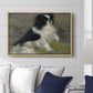Tama, the Japanese Dog, c. 1876 by Pierre-Auguste Renoir displayed above a sofa in a living room in a natural wood floater frame, featuring an impressionist painting of a dog wading through water with blurred background.
