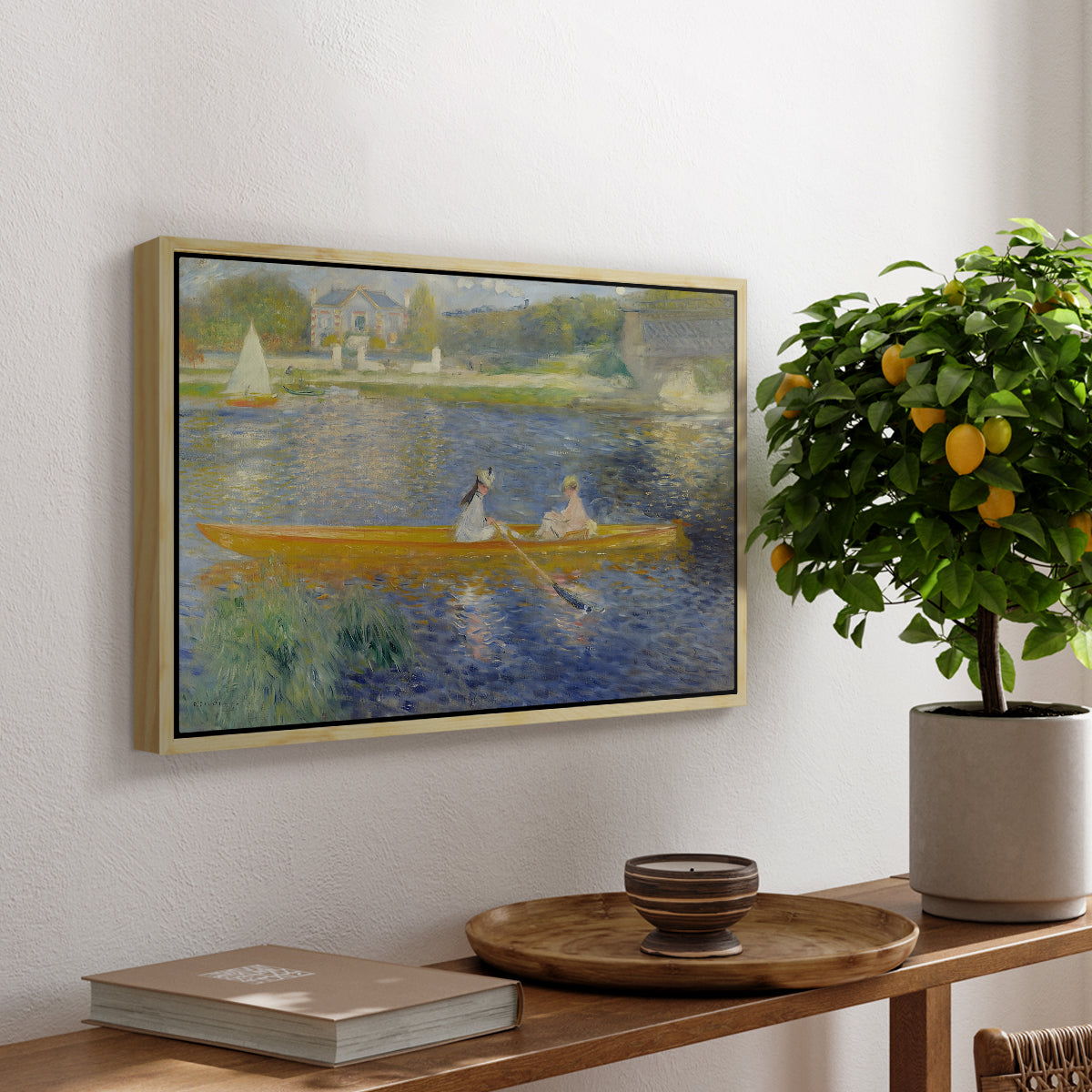The Skiff (La Yole), 1875 by Pierre-Auguste Renoir, presented in a natural wood floater framed canvas featuring two figures seated in a small boat drifting across calm water, displayed above a hallway console table.