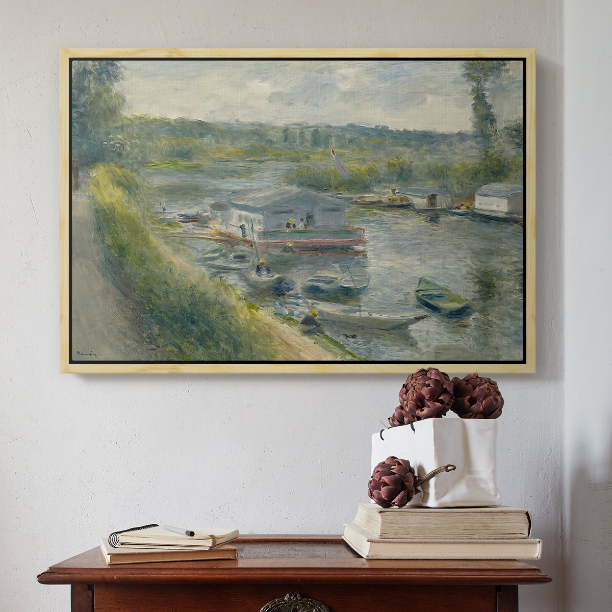Natural wood floater framed canvas featuring Wash-House Boat at Bas-Meudon, c. 1874 by Pierre-Auguste Renoir above an entryway table in a minimalist foyer.
