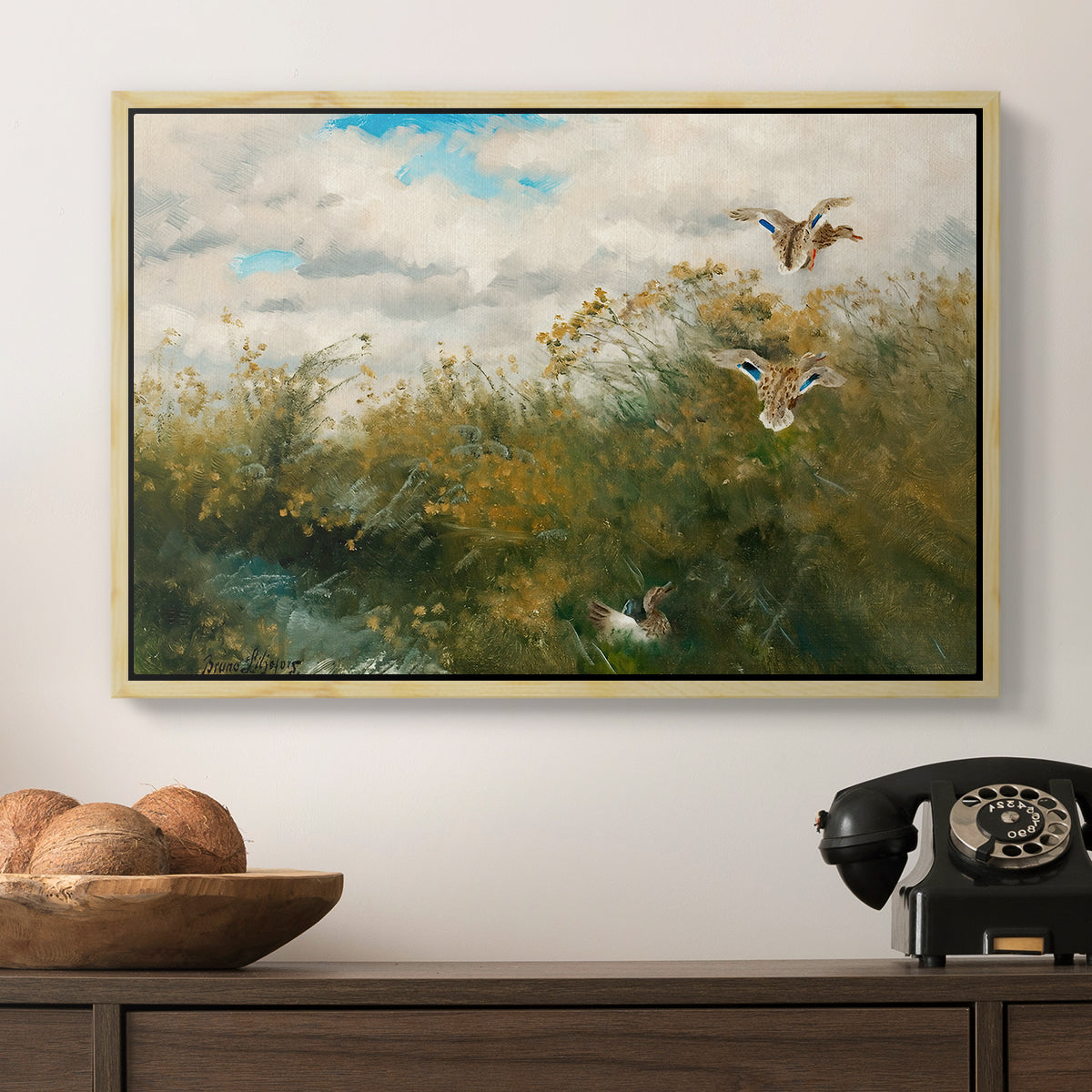 Wild Ducks (Grasänder), 1890 by Bruno Liljefors in a natural wood floater framed canvas displayed above a console table in a hallway, featuring a realistic depiction of ducks in countryside landscape.