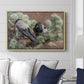 Hooded Crows (Kråkor), 1891 by Bruno Liljefors displayed above a sofa in a living room in a natural wood floater frame, featuring birds standing alert in natural field environment.