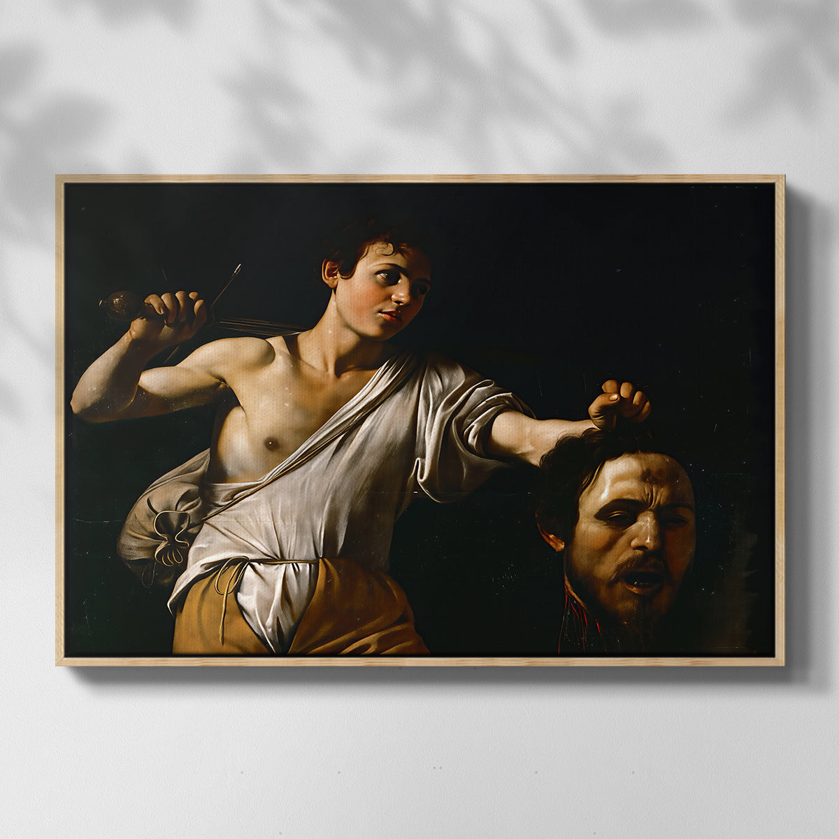 Front view of David with the Head of Goliath (Vienna Version), c. 1607 by Caravaggio in a natural wood floater framed canvas.