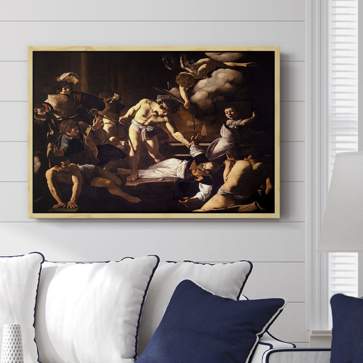 The Martyrdom of Saint Matthew, 1599-1600 by Caravaggio displayed above a sofa in a living room in a natural wood floater frame, featuring a dramatic moment of martyrdom with figures reacting in panic.