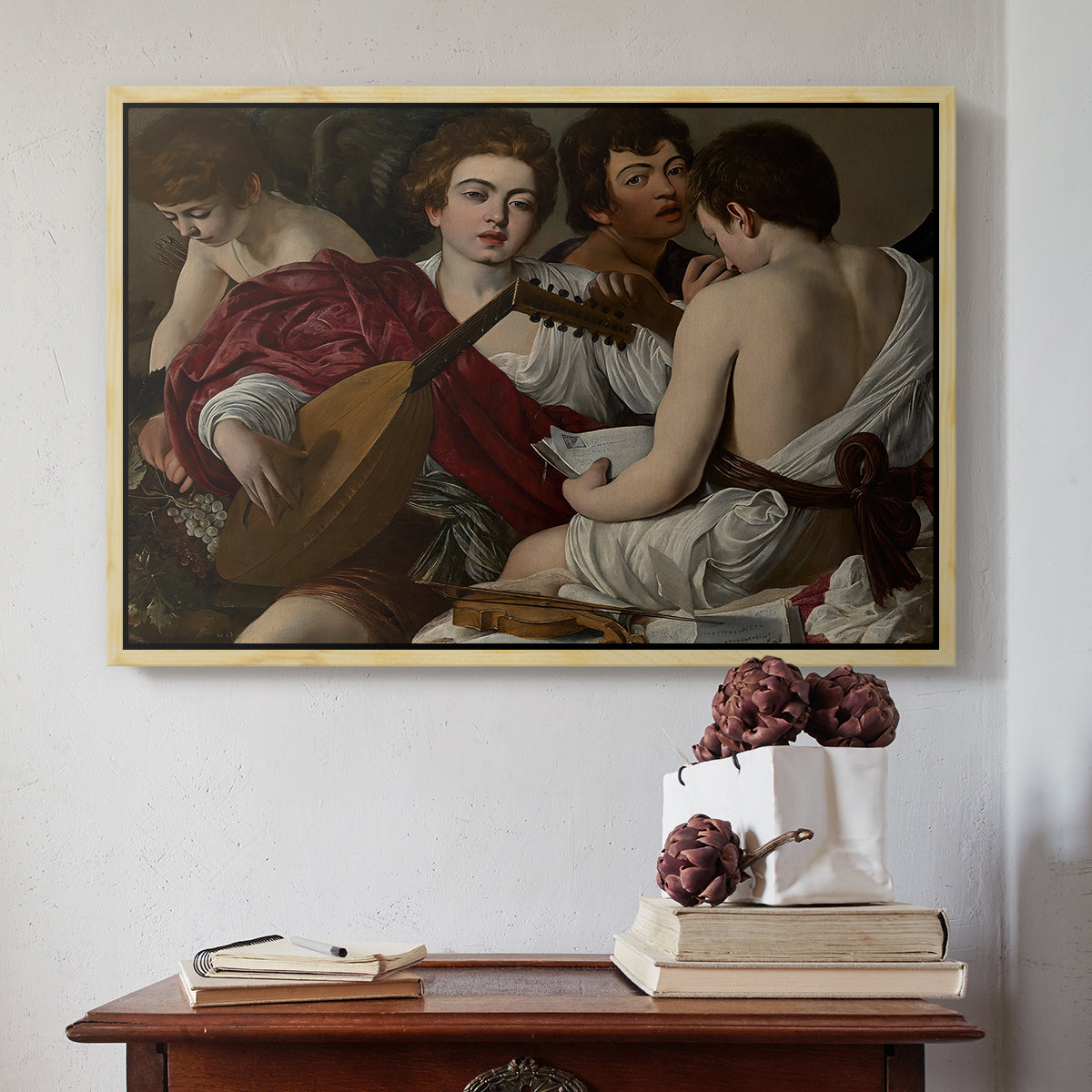 Natural wood floater framed canvas featuring The Musicians, c. 1595 by Caravaggio above an entryway table in a minimalist foyer.