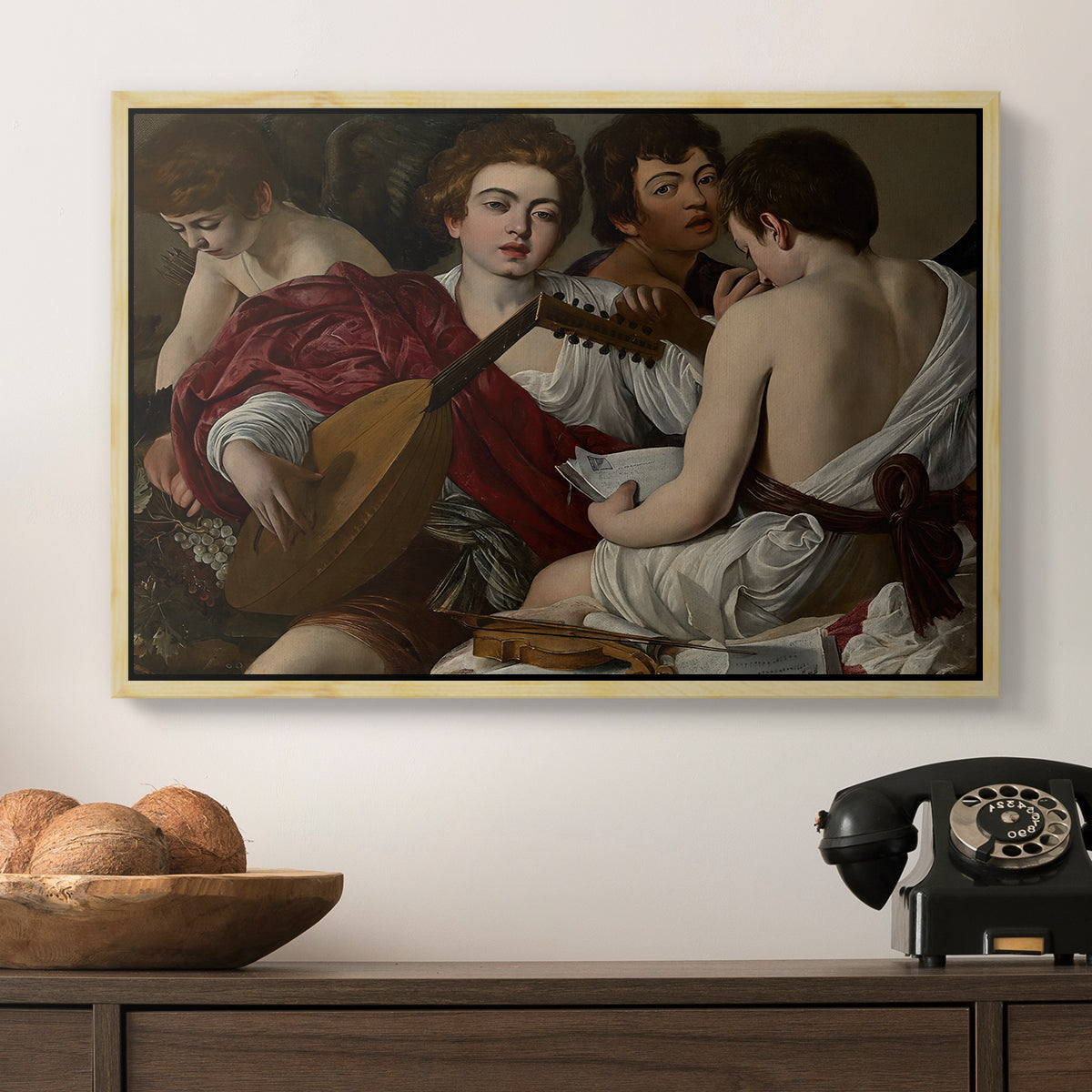 The Musicians, c. 1595 by Caravaggio in a natural wood floater framed canvas displayed above a console table in a hallway, featuring a musical gathering with figures posed closely in soft light.
