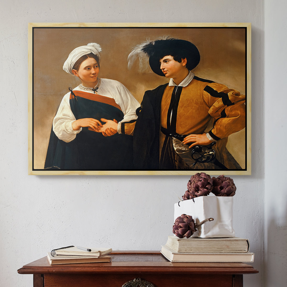 Natural wood floater framed canvas featuring The Fortune Teller (Capitoline Version), c. 1599 by Caravaggio above an entryway table in a minimalist foyer.