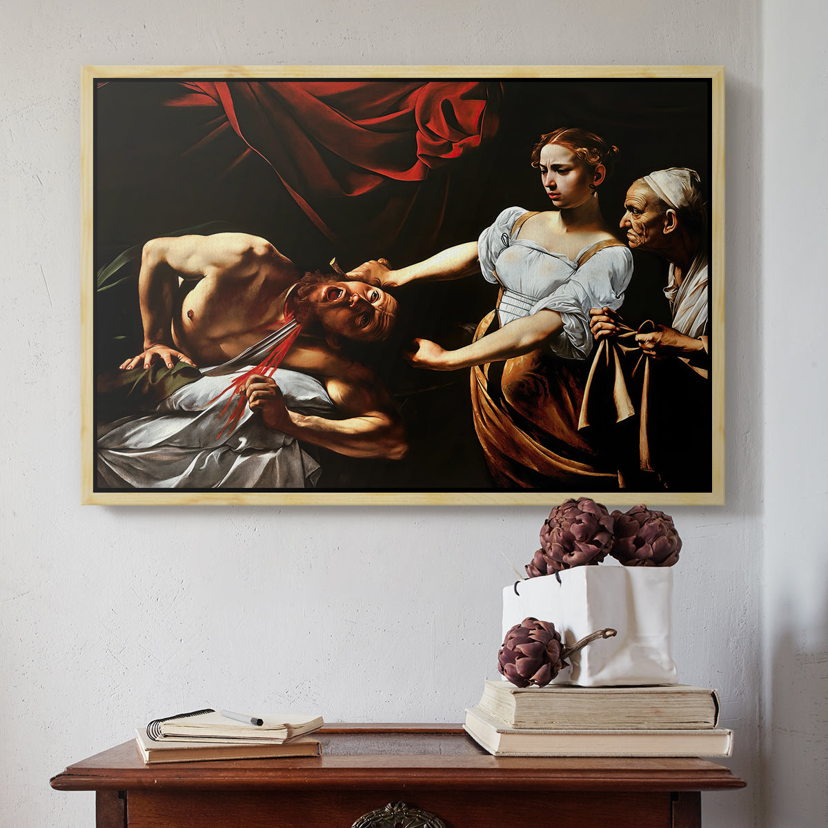 Natural wood floater framed canvas featuring Judith Beheading Holofernes, c. 1599 by Caravaggio above an entryway table in a minimalist foyer.