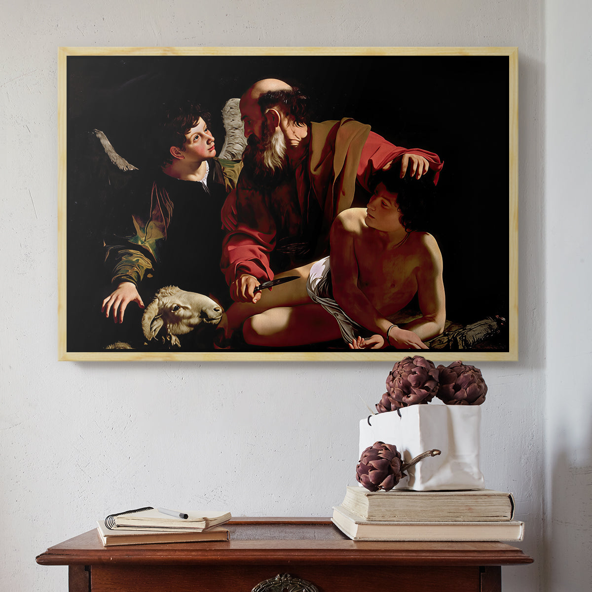 Natural wood floater framed canvas featuring The Sacrifice of Isaac (Uffizi Version), c. 1603 by Caravaggio above an entryway table in a minimalist foyer.