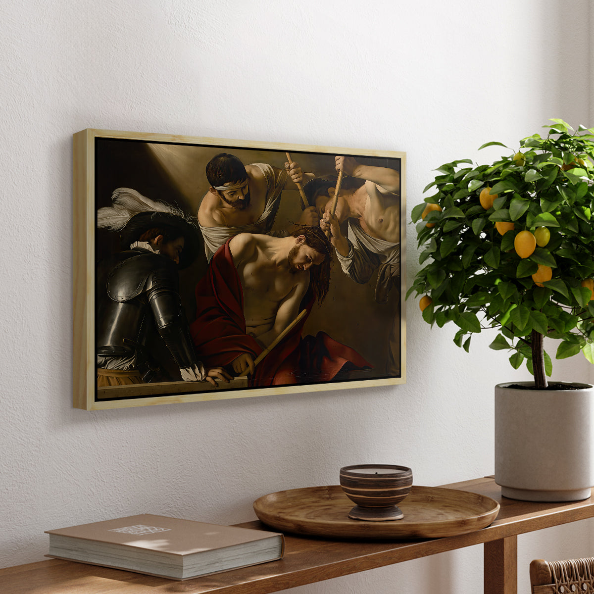 The Crowning with Thorns (Vienna Version), c. 1602-1604 by Caravaggio, presented in a natural wood floater framed canvas featuring Christ surrounded by men pressing crown of thorns onto his head, displayed above a hallway console table.