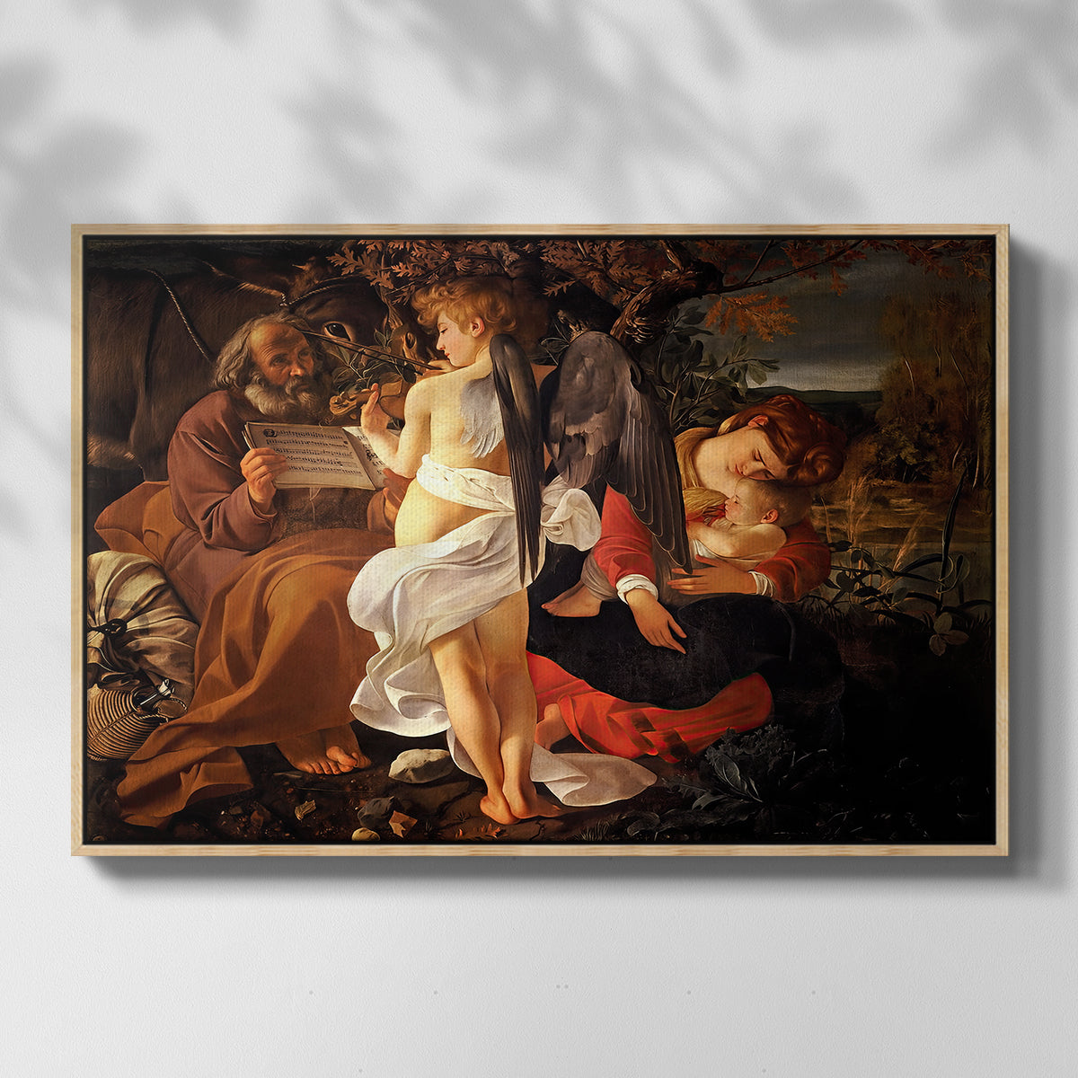 Front view of Rest on the Flight into Egypt, c. 1597 by Caravaggio in a natural wood floater framed canvas.