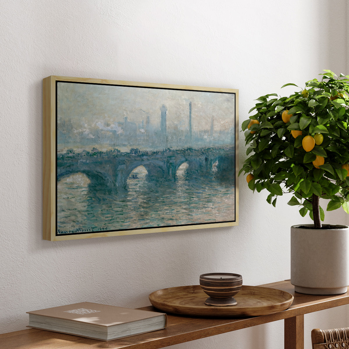 Waterloo Bridge, Gray Weather, 1900 by Claude Monet, presented in a natural wood floater framed canvas featuring a hazy view of Waterloo Bridge over river in gray atmospheric light, displayed above a hallway console table.