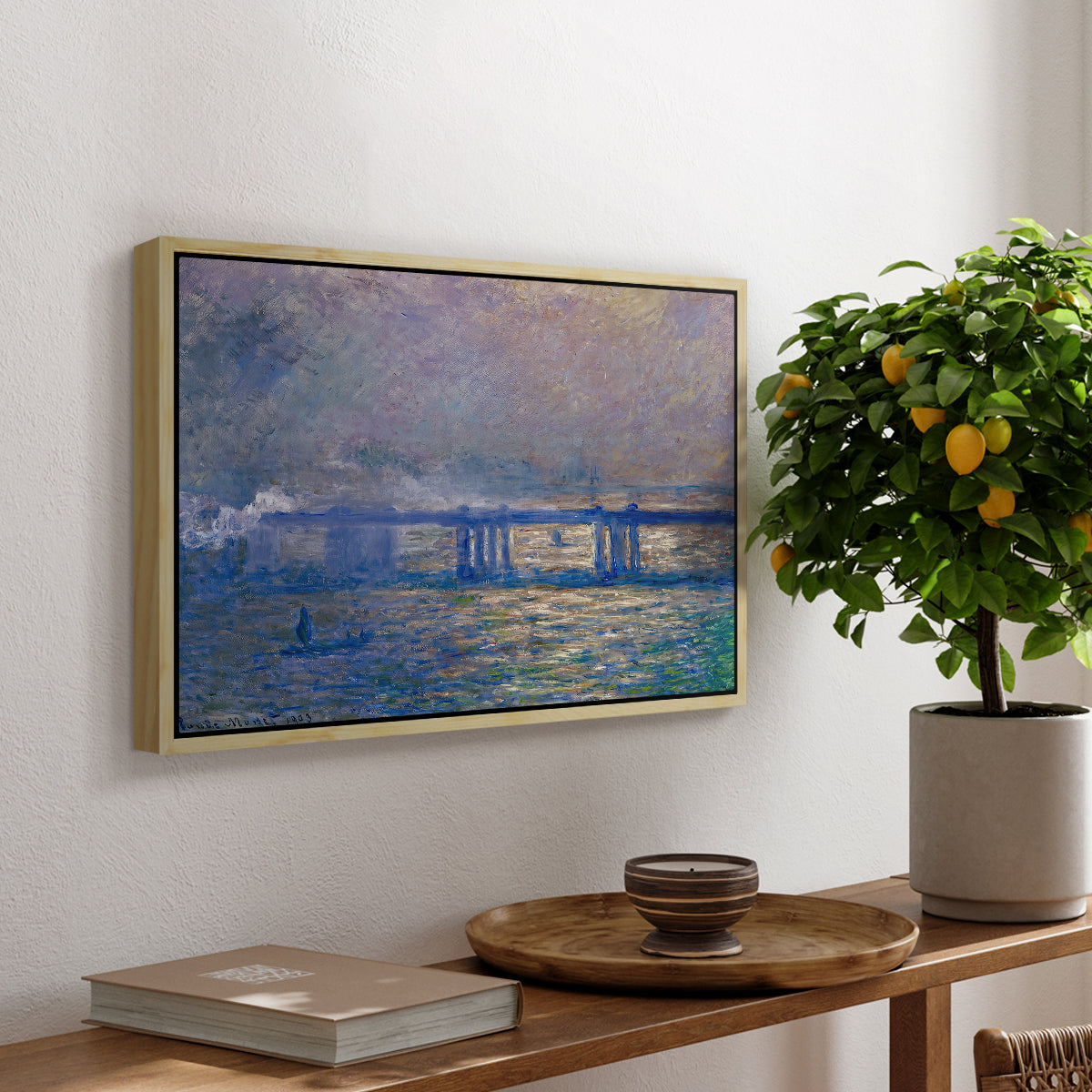Charing Cross Bridge, 1903 by Claude Monet, presented in a natural wood floater framed canvas featuring an impressionist view of bridge stretching across river with soft light and haze, displayed above a hallway console table.