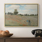 The Poppy Field near Argenteuil, 1873 by Claude Monet in a natural wood floater framed canvas displayed above a console table in a hallway, featuring a rural landscape with scattered figures among blooming flowers.