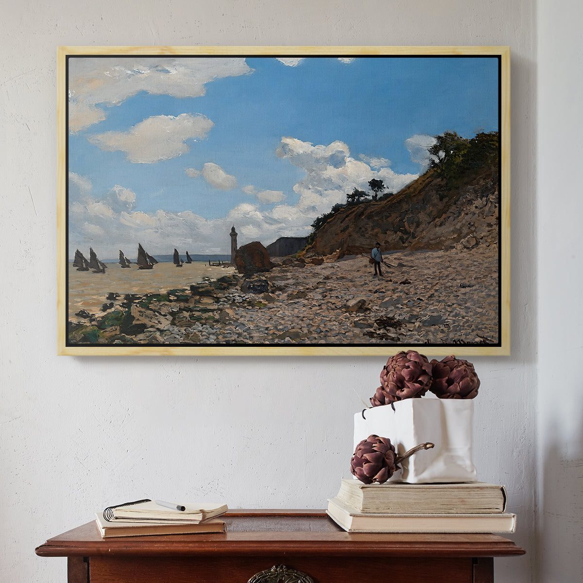 Natural wood floater framed canvas featuring The Beach at Honfleur, 1864 by Claude Monet above an entryway table in a minimalist foyer.