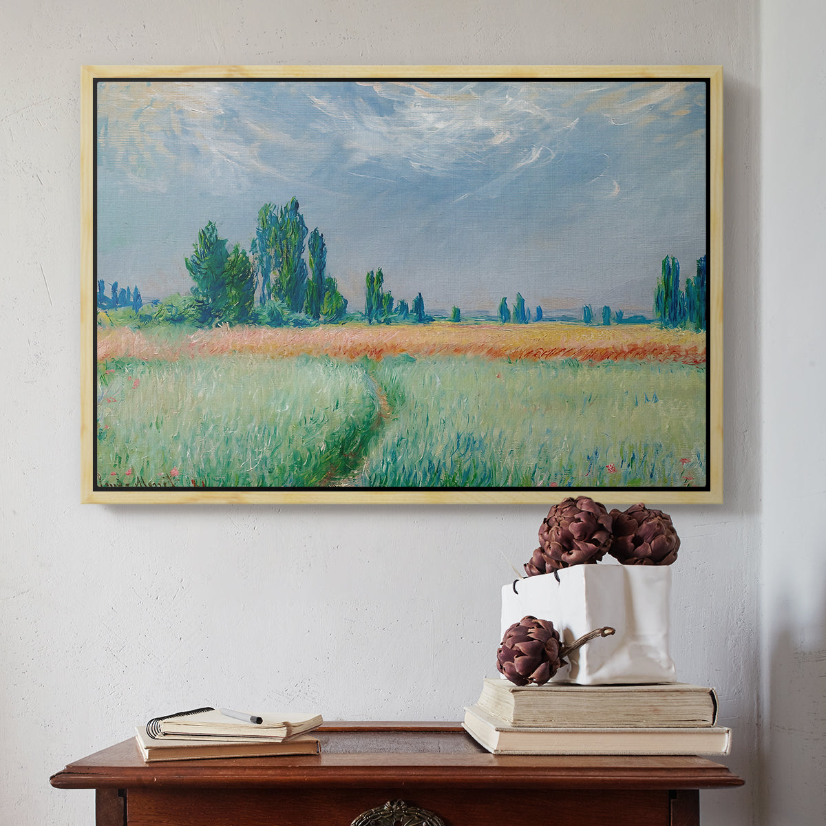 Natural wood floater framed canvas featuring The Wheat Field (Champ de Blé), 1881 by Claude Monet above an entryway table in a minimalist foyer.