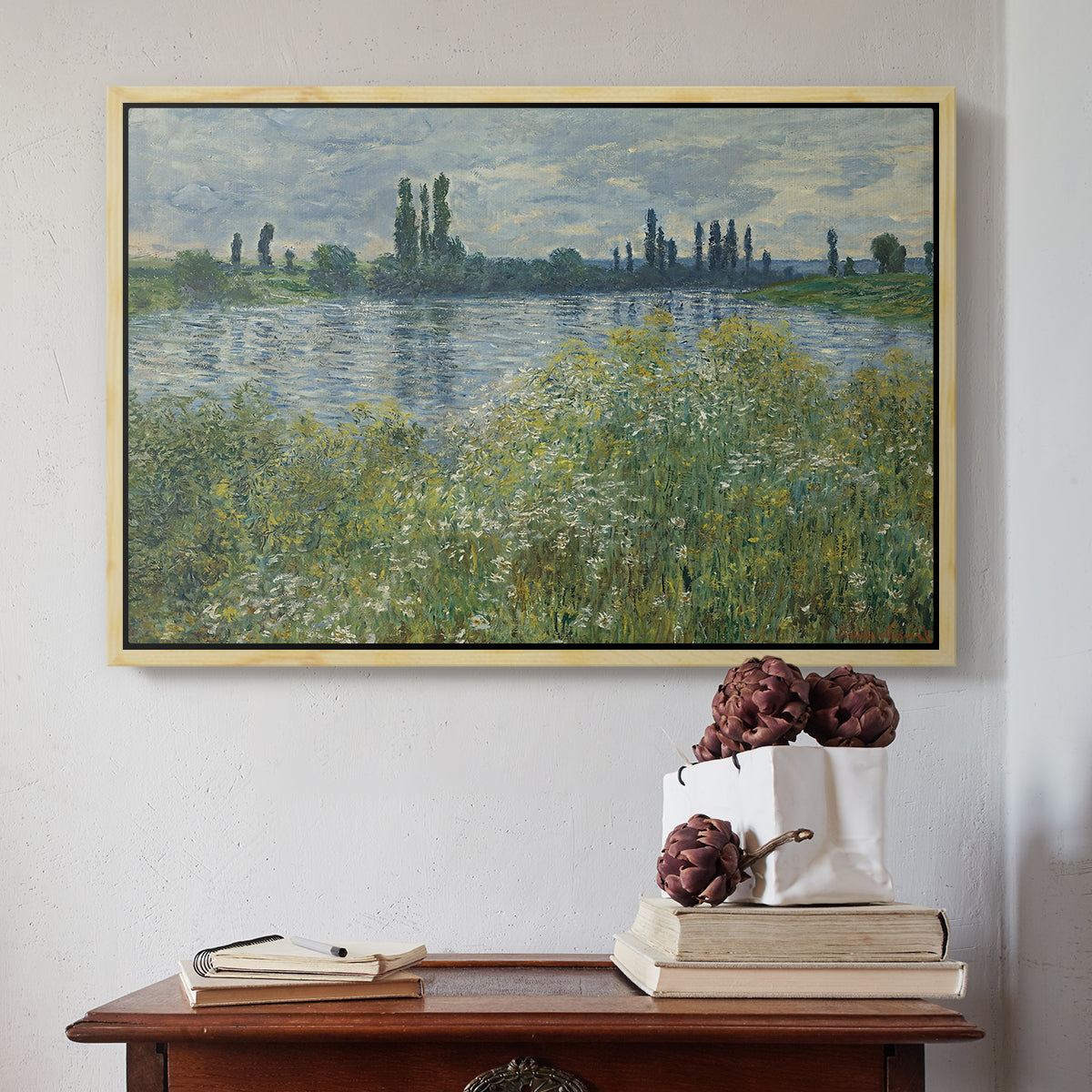 Natural wood floater framed canvas featuring Banks of the Seine, Vétheuil, 1880 by Claude Monet above an entryway table in a minimalist foyer.