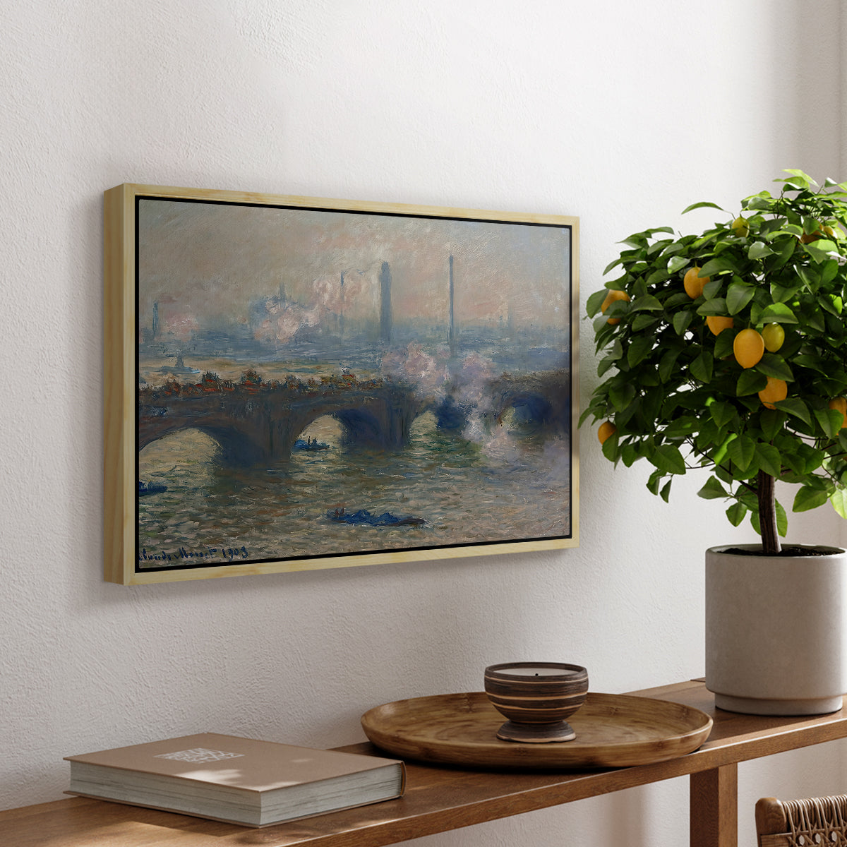 Waterloo Bridge, Gray Day, 1903 by Claude Monet, presented in a natural wood floater framed canvas featuring a muted cityscape of bridge spanning river under overcast sky, displayed above a hallway console table.