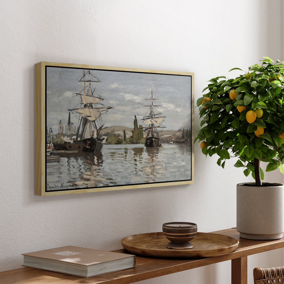 Ships Riding on the Seine at Rouen, 1872 by Claude Monet, presented in a natural wood floater framed canvas featuring large ships docked along the Seine with masts rising against soft sky, displayed above a hallway console table.