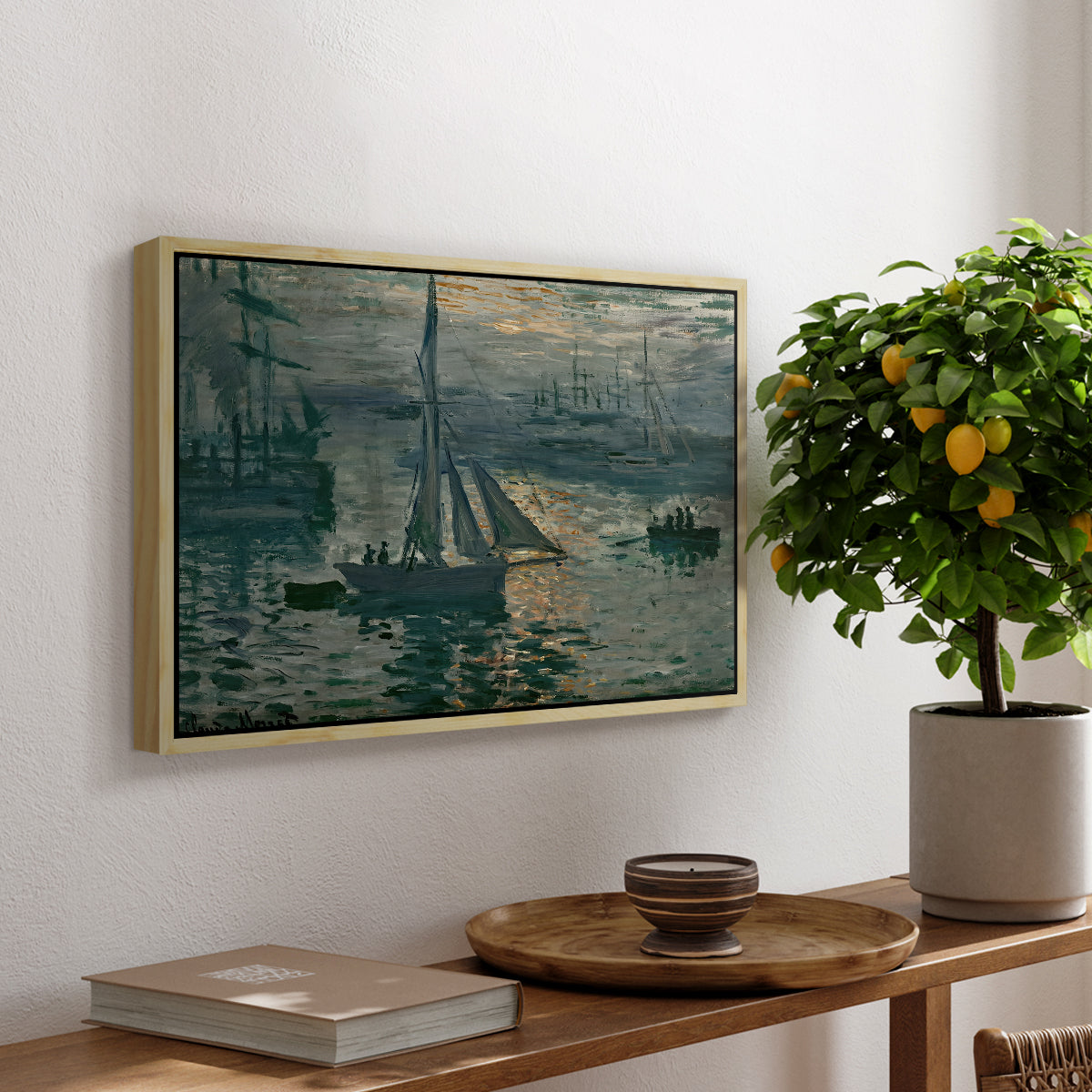 Sunrise (Marine), 1873 by Claude Monet, presented in a natural wood floater framed canvas featuring a hazy sunrise over harbor with boats silhouetted in soft morning light, displayed above a hallway console table.