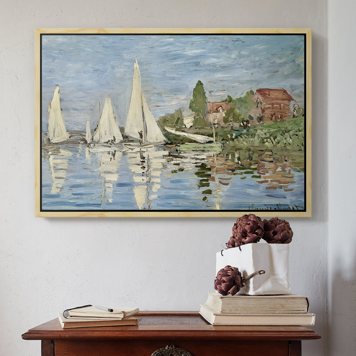 Natural wood floater framed canvas featuring Regatta at Argenteuil, 1872 by Claude Monet above an entryway table in a minimalist foyer.