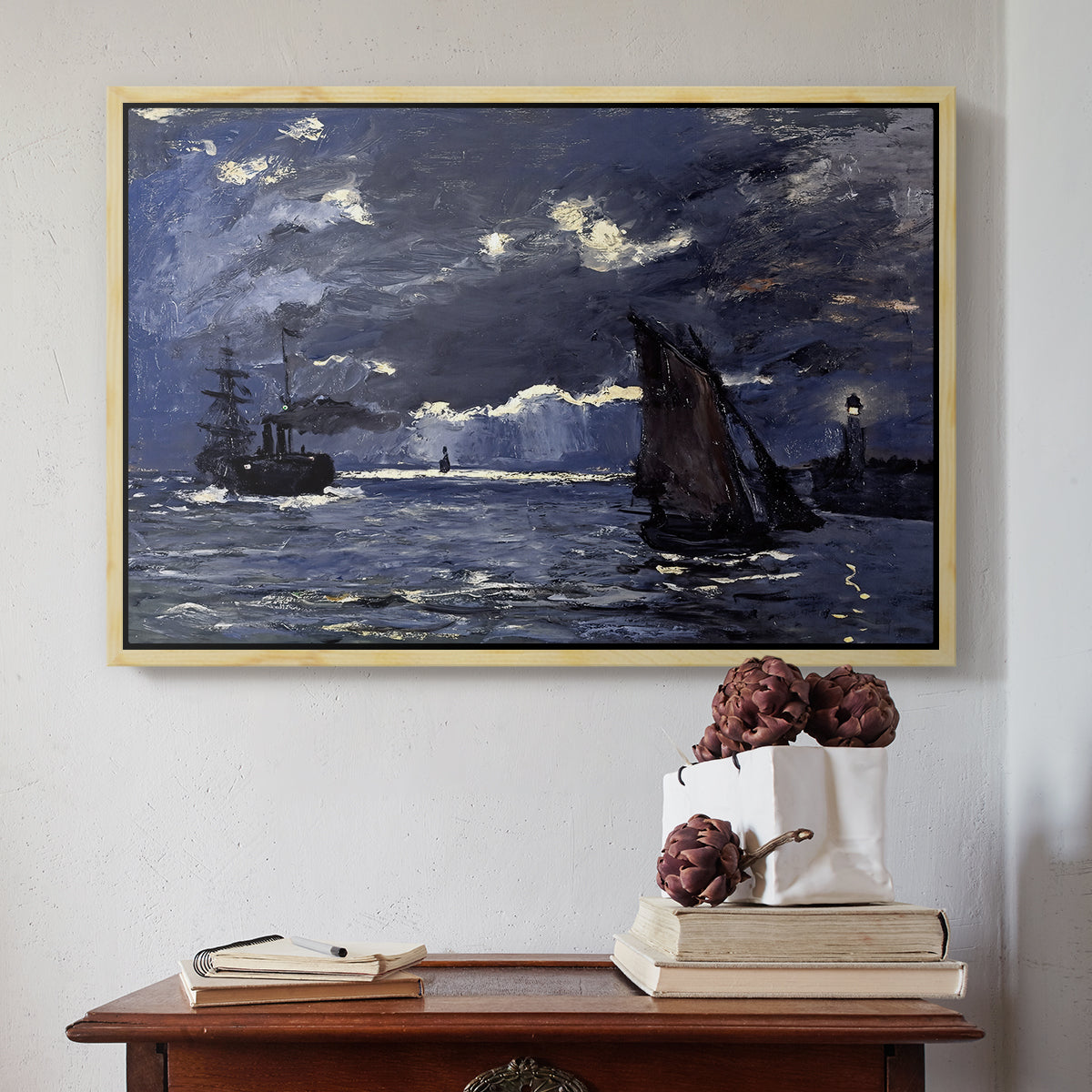 Natural wood floater framed canvas featuring A Seascape, Shipping by Moonlight, 1864 by Claude Monet above an entryway table in a minimalist foyer.