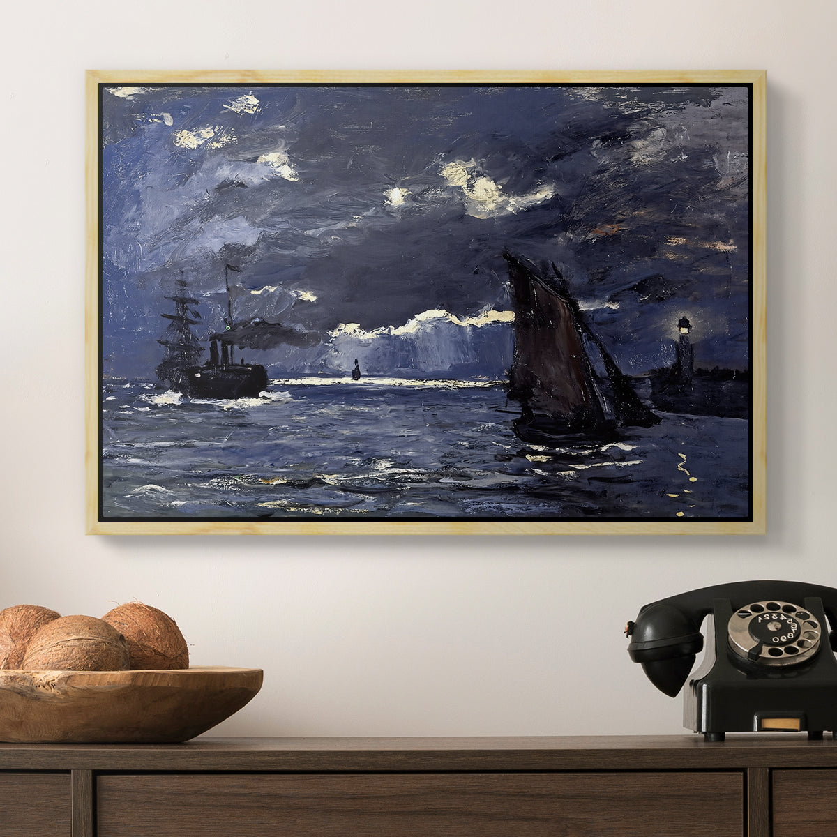 A Seascape, Shipping by Moonlight, 1864 by Claude Monet in a natural wood floater framed canvas displayed above a console table in a hallway, featuring an atmospheric maritime view with ships in moonlit darkness.