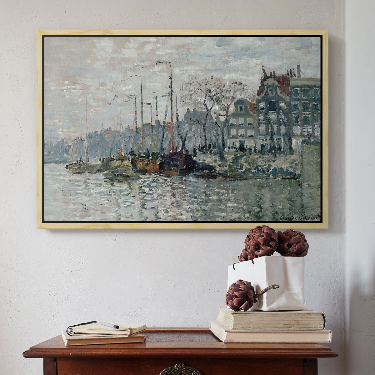 Natural wood floater framed canvas featuring View of the Prins Hendrikkade and Kromme Waal in Amsterdam, 1874 by Claude Monet above an entryway table in a minimalist foyer.
