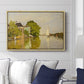 Houses on the Achterzaan, 1871 by Claude Monet displayed above a sofa in a living room in a natural wood floater frame, featuring riverside homes with trees and mirrored reflections in water.