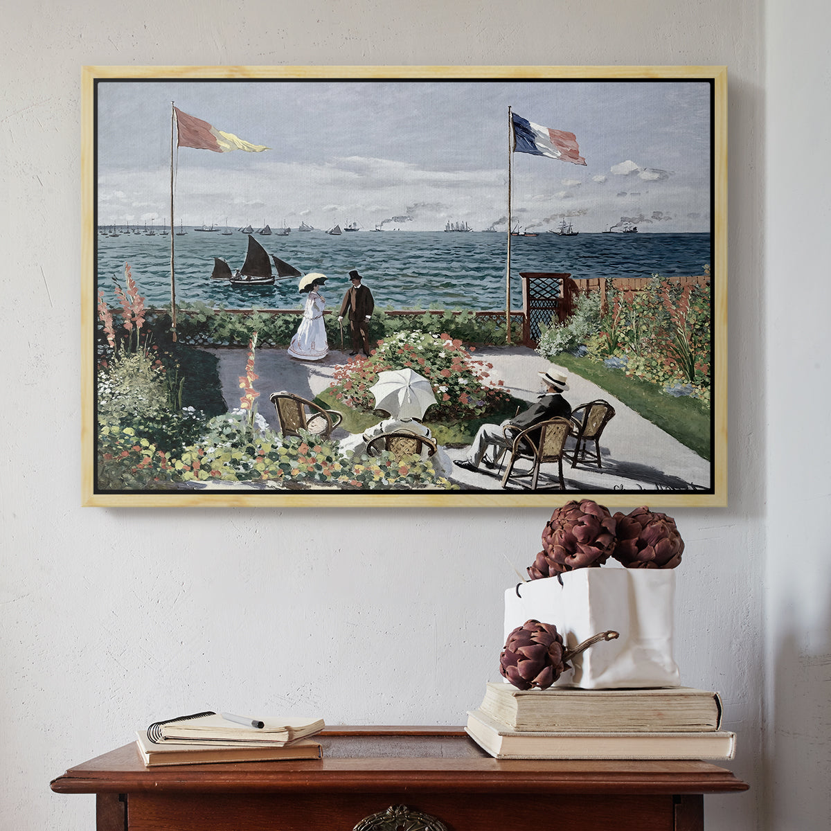 Natural wood floater framed canvas featuring Garden at Sainte-Adresse, 1867 by Claude Monet above an entryway table in a minimalist foyer.