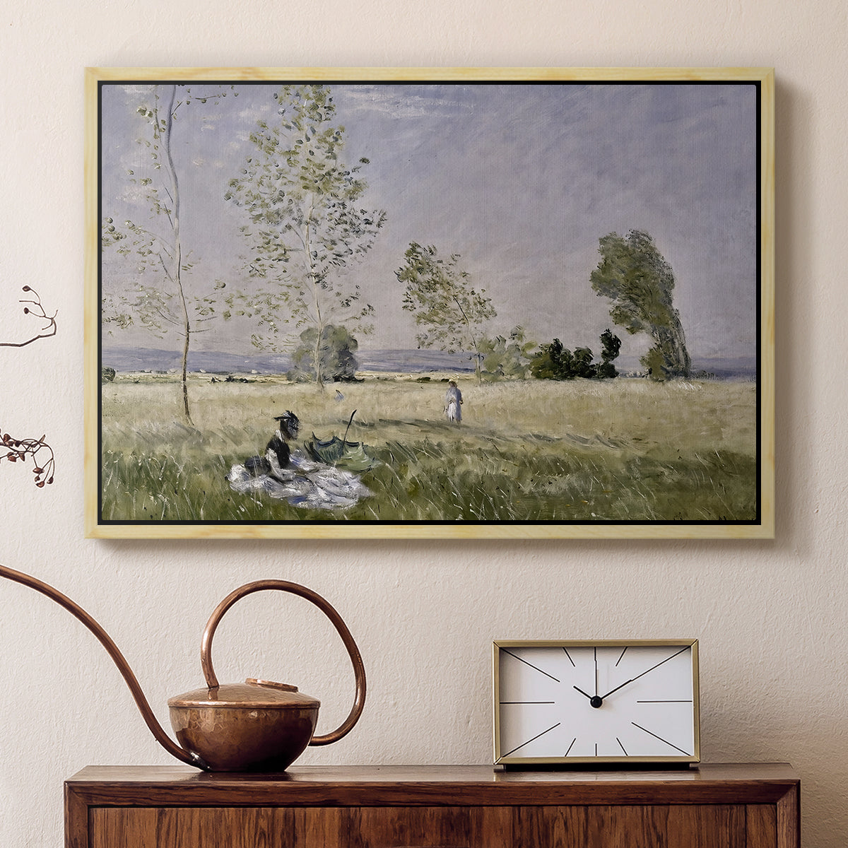 Natural wood floater framed canvas featuring a sunlit meadow with woman surrounded by greenery, displayed above a cabinet in a soft-toned living room.
