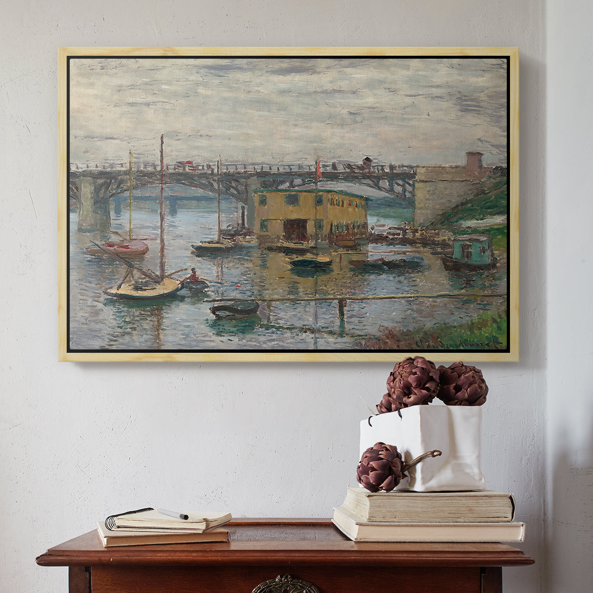 Natural wood floater framed canvas featuring Bridge at Argenteuil on a Gray Day, c. 1876 by Claude Monet above an entryway table in a minimalist foyer.