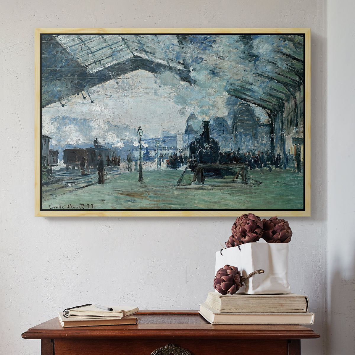 Natural wood floater framed canvas featuring The Saint-Lazare Station, 1877 by Claude Monet above an entryway table in a minimalist foyer.
