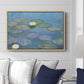 Water Lilies (Nymphéas), 1897-1899 by Claude Monet displayed above a sofa in a living room in a natural wood floater frame, featuring an impressionist pond scene with lily pads and soft reflections.