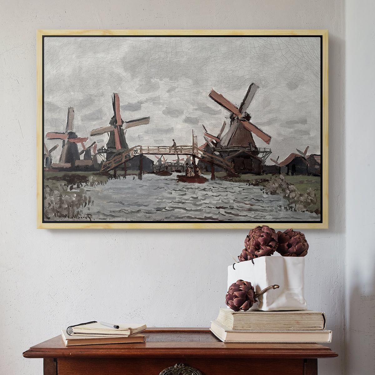 Natural wood floater framed canvas featuring Windmills near Zaandam, 1871 by Claude Monet above an entryway table in a minimalist foyer.
