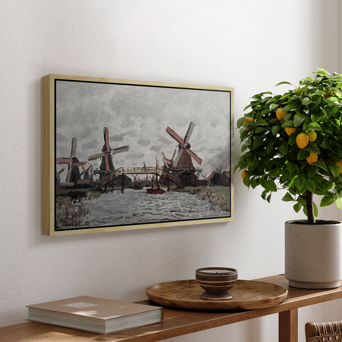 Windmills near Zaandam, 1871 by Claude Monet, presented in a natural wood floater framed canvas featuring windmills standing beside water under open sky in rural landscape, displayed above a hallway console table.