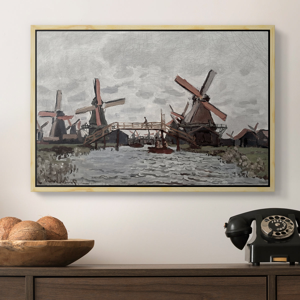 Windmills near Zaandam, 1871 by Claude Monet in a natural wood floater framed canvas displayed above a console table in a hallway, featuring a landscape featuring windmills and low horizon sky.
