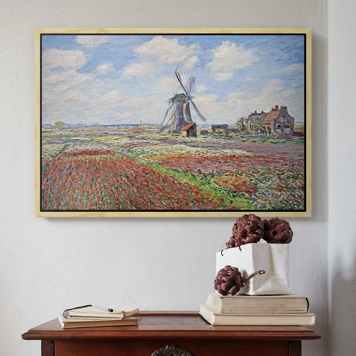 Natural wood floater framed canvas featuring Tulip Fields with the Rijnsburg Windmill, 1886 by Claude Monet above an entryway table in a minimalist foyer.