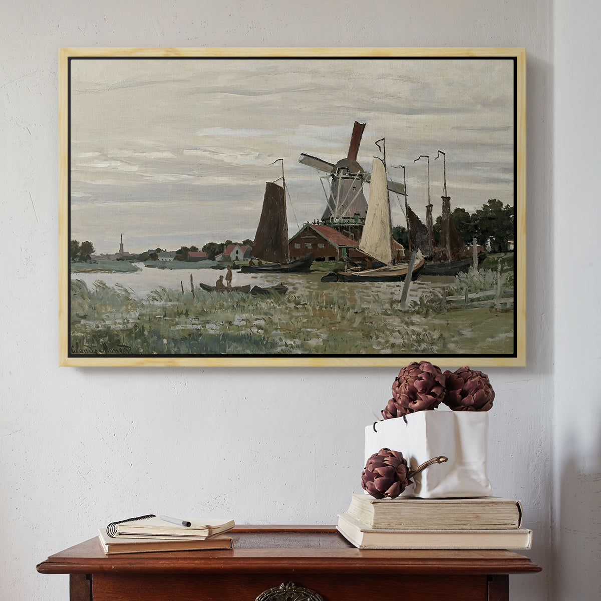 Natural wood floater framed canvas featuring Windmill at Zaandam, 1871 by Claude Monet above an entryway table in a minimalist foyer.
