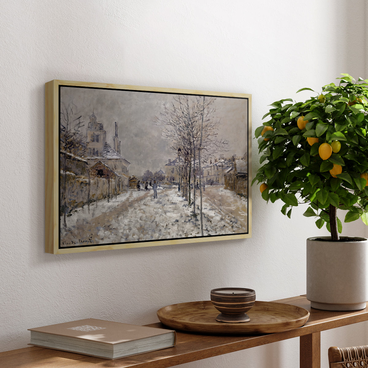 The Boulevard de Pontoise at Argenteuil, Snow Effect, 1875 by Claude Monet, presented in a natural wood floater framed canvas featuring a snow-covered street lined with trees and buildings under winter sky, displayed above a hallway console table.