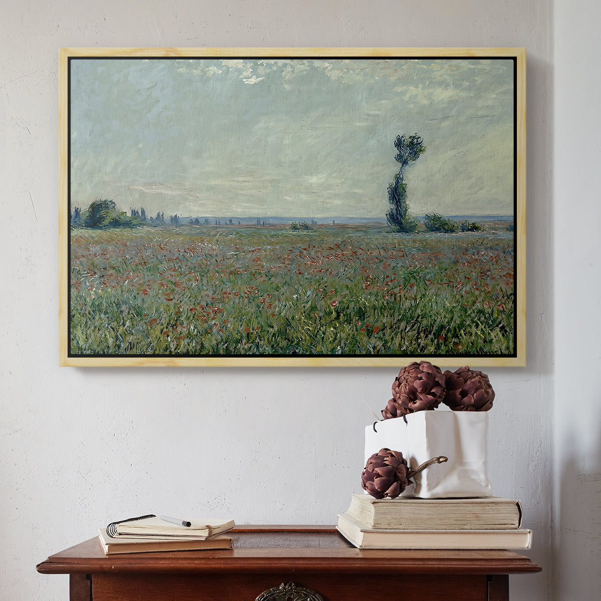 Natural wood floater framed canvas featuring Poppy Field, 1881 by Claude Monet above an entryway table in a minimalist foyer.