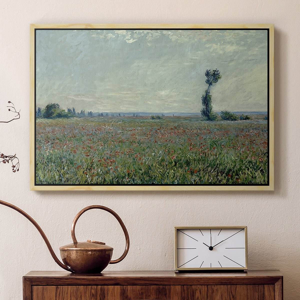 Natural wood floater framed canvas featuring a rural meadow with scattered poppies and soft horizon, displayed above a cabinet in a soft-toned living room.