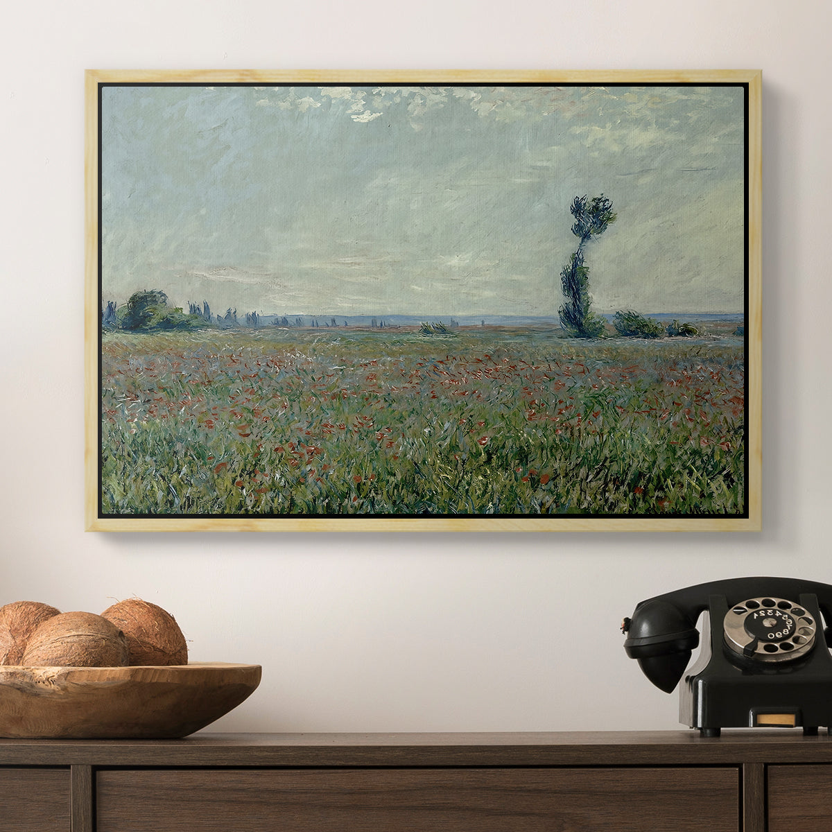 Poppy Field, 1881 by Claude Monet in a natural wood floater framed canvas displayed above a console table in a hallway, featuring a natural field scene with vibrant red flowers.
