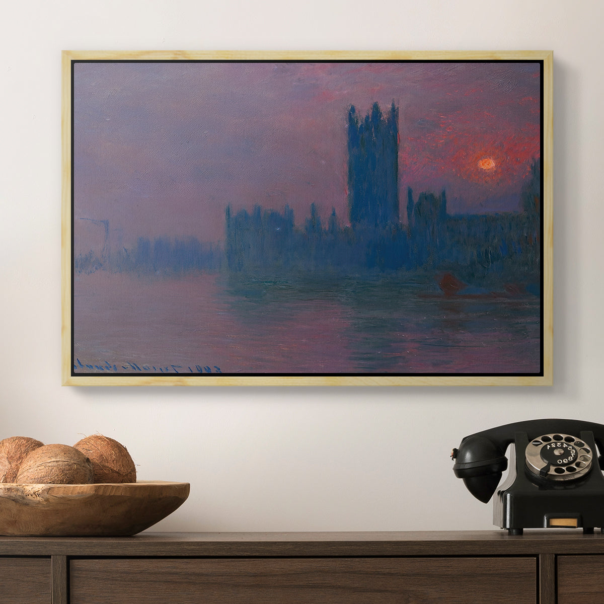 The Houses of Parliament, Sunset, 1903 by Claude Monet in a natural wood floater framed canvas displayed above a console table in a hallway, featuring a dramatic skyline with reflections under colorful sky.