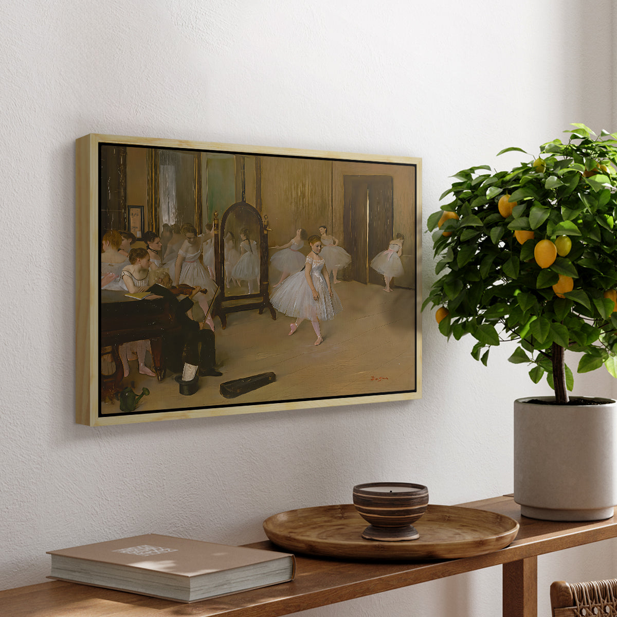 The Dancing Class, c. 1870 by Edgar Degas, presented in a natural wood floater framed canvas featuring a ballet class with dancers practicing positions under instructor guidance, displayed above a hallway console table.